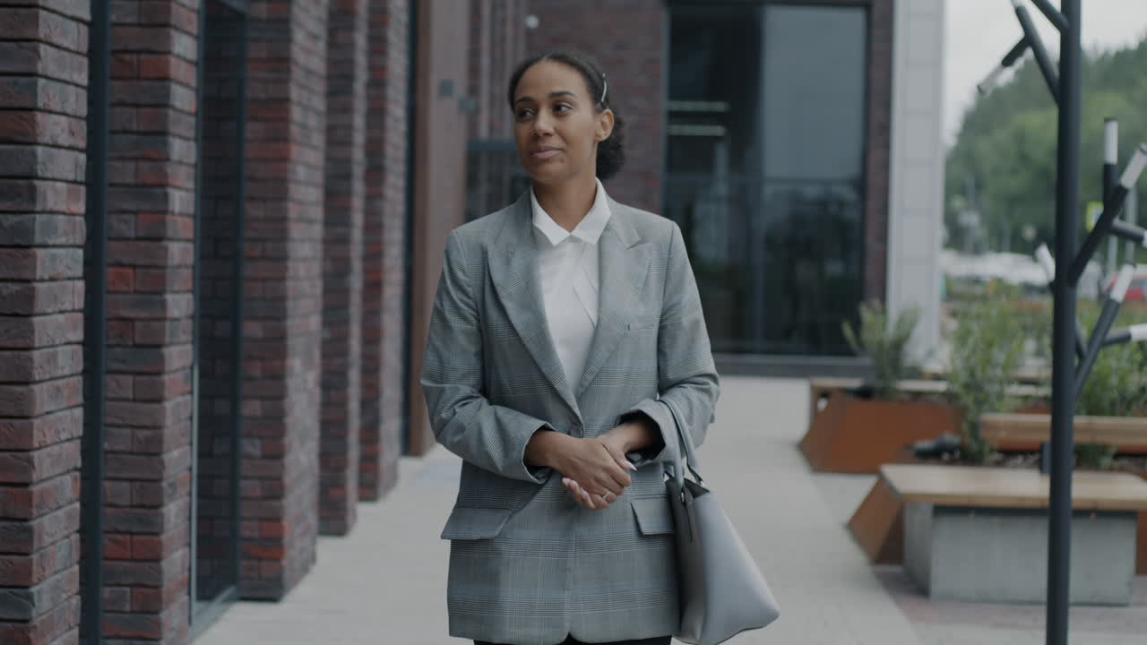 mujer de negocios caminando fuera de un edificio moderno