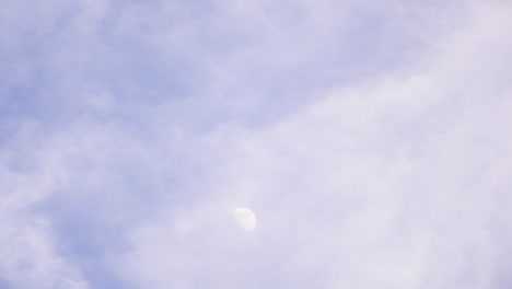 misty clouds passing in timelapse shot of moon at daytime