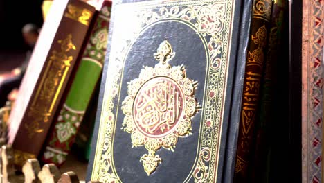 sunlight hitting cover of muslim quran islamic holy books shiny black and gold print