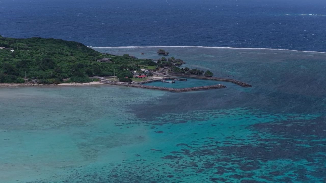 Riprese aeree orizzontali con lento movimento in avanti sopra la costa e le acque turchesi che circondano l'isola di Ogami, Miyakojima, Okinawa, Giappone.
