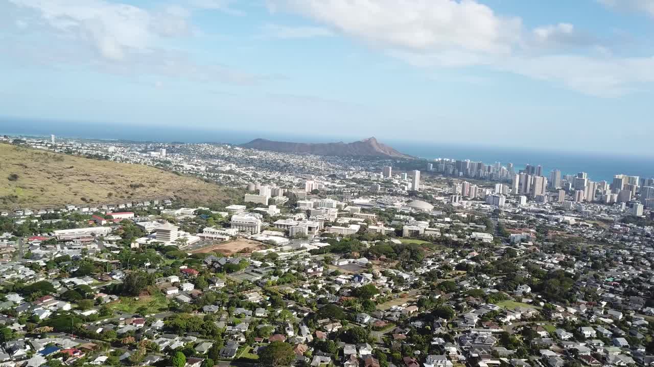 Aerial wide shot of suburb neighborhood and downtown of Honolulu city on Hawaii, USA. Sunny Summer day with blue ocean in distance