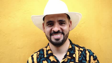 hispanic man in hat near yellow wall