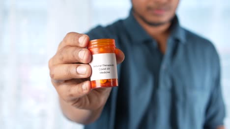 persona que tiene un recipiente de medicamento antiviral para la covid-19