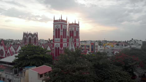 grúa aérea arriba revela una toma de la iglesia bascillia del sagrado corazón en pondicherry con el sol saliendo detrás de ella, filmada con un dron en 4k