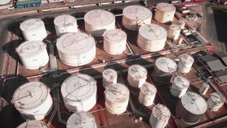 chemical industry storage tanks at refinery plant. rows of huge white fuel and gas tanks at industrial refinery complex. big cylindrical liquefied natural gas reservoirs at big fuel and oil factory