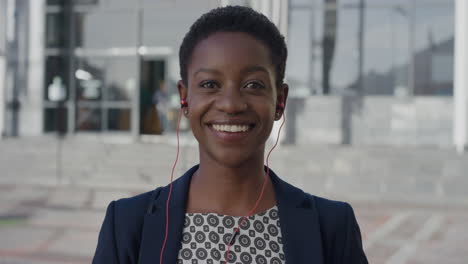 retrato en primer plano feliz mujer de negocios afroamericana ejecutiva riendo disfrutando del estilo de vida urbano profesional en la ciudad usando auriculares escuchando música