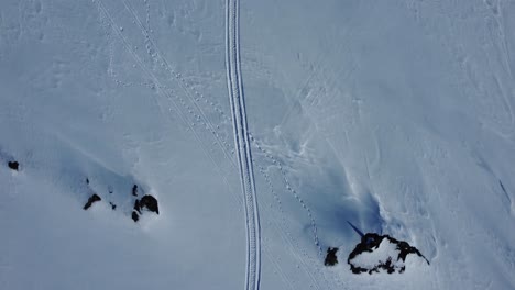 Vista-Aérea-De-Arriba-Hacia-Abajo-De-Pistas-De-Trineo-Y-Huellas-En-La-Nieve