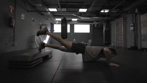 Young-athletic-man-doing-push-ups-at-the-gym