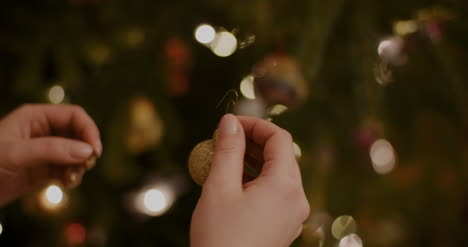 mujer joven decorando el árbol de navidad en casa