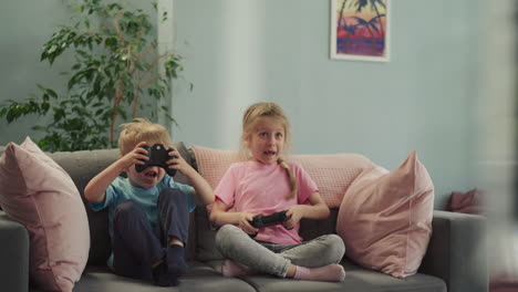 Happy-siblings-control-gaming-consoles-to-compete-in-game