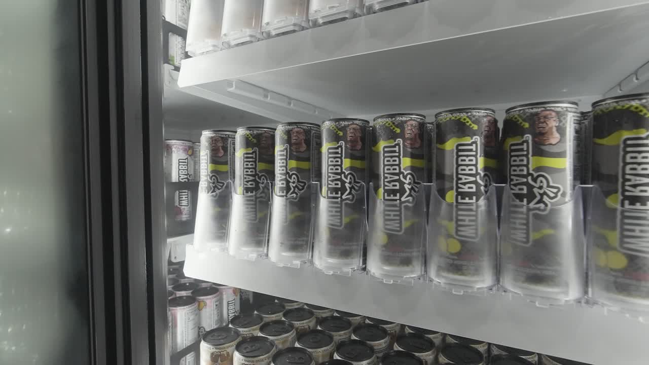 PRIME Hydration beverage cans on a store shelf in a refrigerator