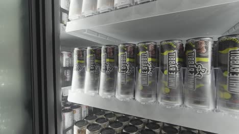 prime hydration beverage cans on a store shelf in a refrigerator