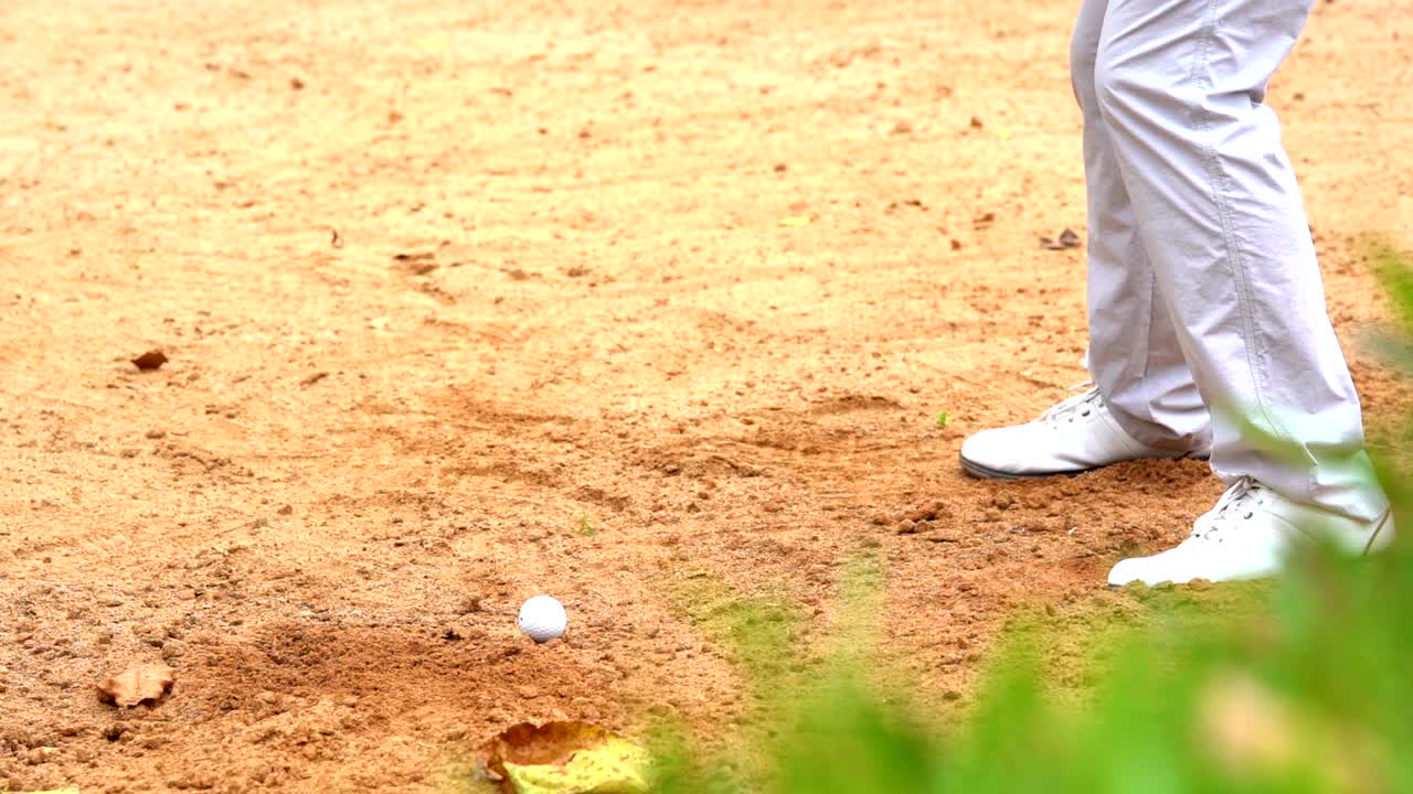 슬로우 모션 골프 개념: 골프 코스에서 골프 공을 치는 골퍼, 플레이어 스, 모래 커에서 느리게 타격하는 공.