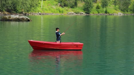 la mujer en el barco atrapa un pez en el giro en noruega.