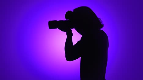 photographer silhouette with camera on purple background