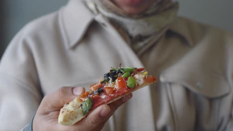 woman eating a slice of pizza