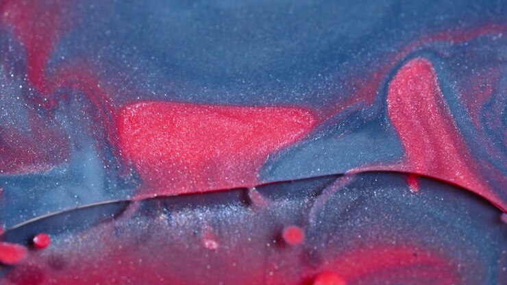 Abstract swirling colors of blue and red ink diffusing in water, creating a mesmerizing fluid pattern, macro shot