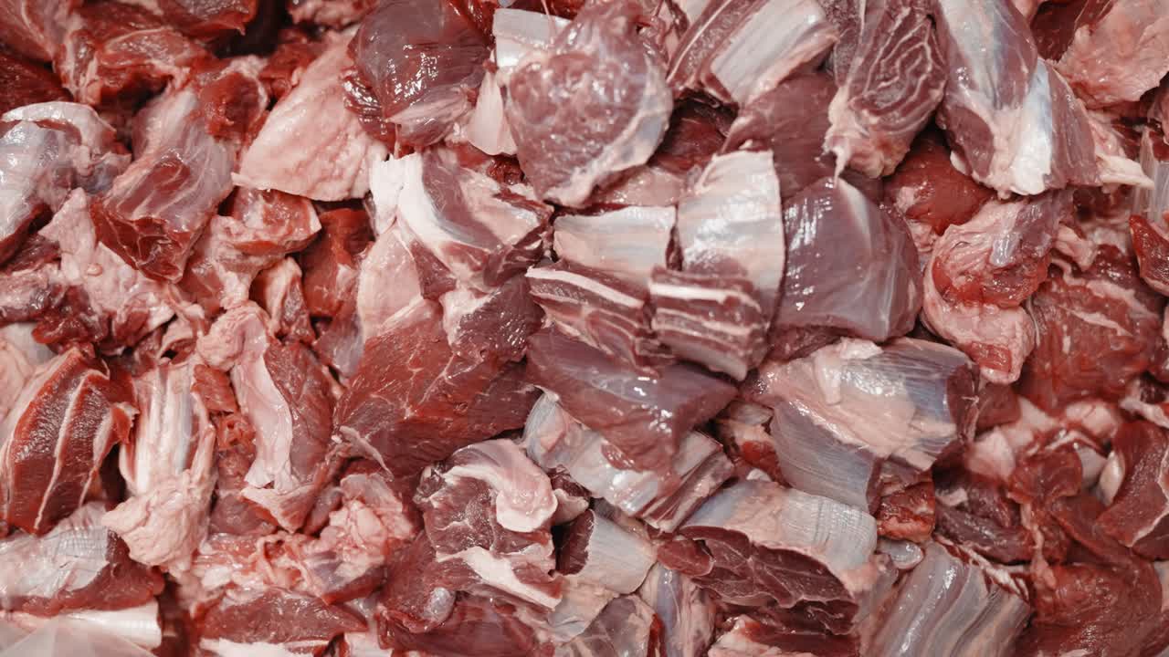 Detailed view of raw pork meat cut into chunks for food processing