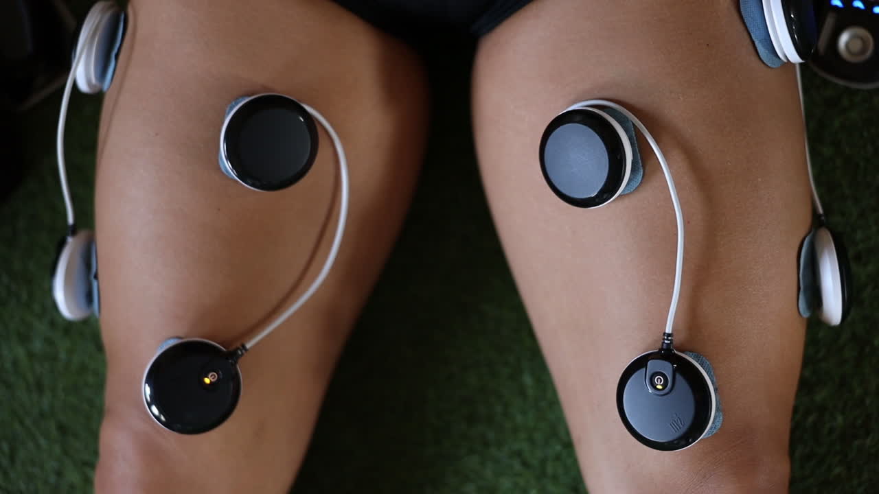 крупным планом кадры использования электровибрационных массажных подушечек на ногах спортсмена