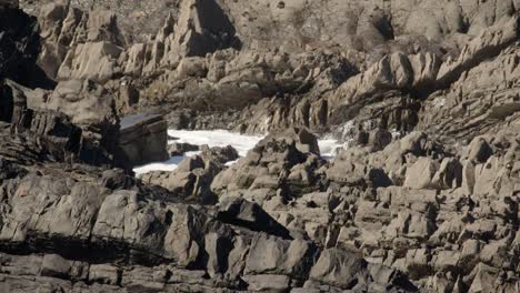 mid shot of sea breaking over jagged sedimentary rocks in the cornish sea at hartland quay, stoke, hartland, bideford