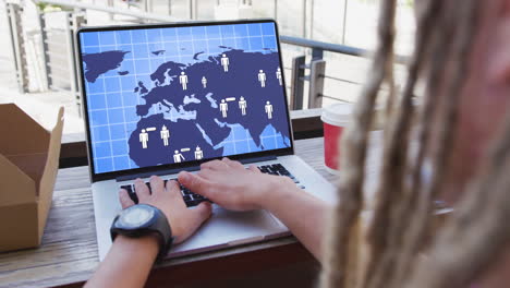 hombre de negocios biracial en la oficina usando una computadora con procesamiento de datos en la pantalla