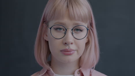 woman with pink hair and glasses