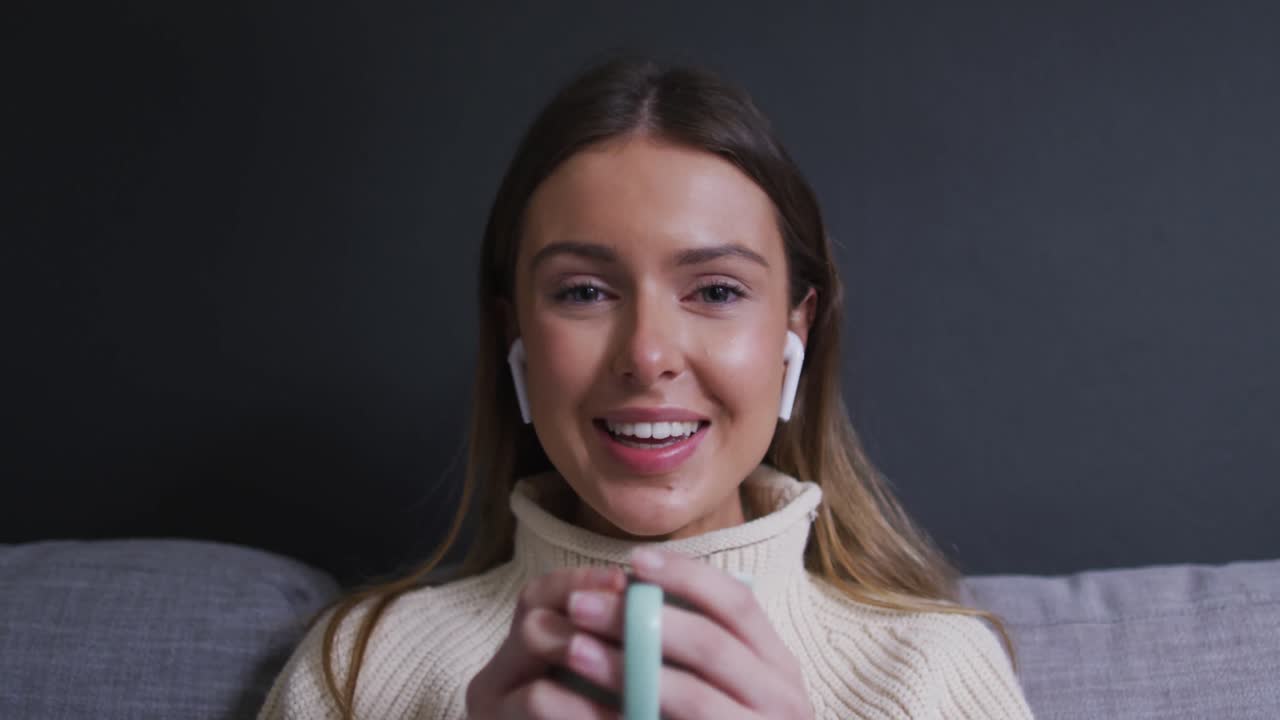 retrato de una mujer agitando la mano mientras bebe café