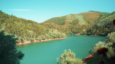 Countryside-river-among-green-mountain-hills-on-summertime-at-sunshine-blue-sky-wide-open-shot-4K