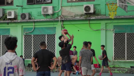 young men playing basketball on an outdoor court
