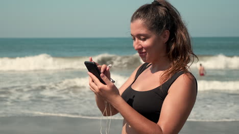 mujer en la playa usando un teléfono inteligente