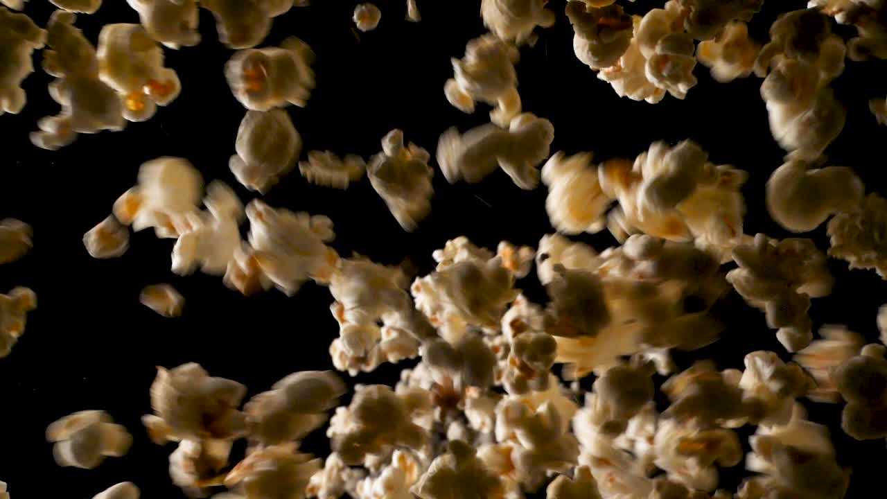 전체 프레임이 덮일 때까지 많은 양의 팝콘이 카메라에서 슬로우 모션으로 떨어집니다.