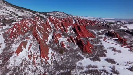 marzo mañana de invierno nieve impresionante parque estatal de roxborough littleton colorado paisaje aéreo drone afilado dentado dramáticas formaciones rocosas rojas pies de denver rango delantero cielo azul movimiento hacia adelante