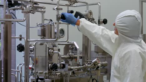 scientist in protective suits working on vat