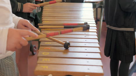 Cerrar-Las-Manos-De-Los-Estudiantes-Usando-Mazos-Para-Tocar-El-Xilófono-Durante-La-Clase-De-Música