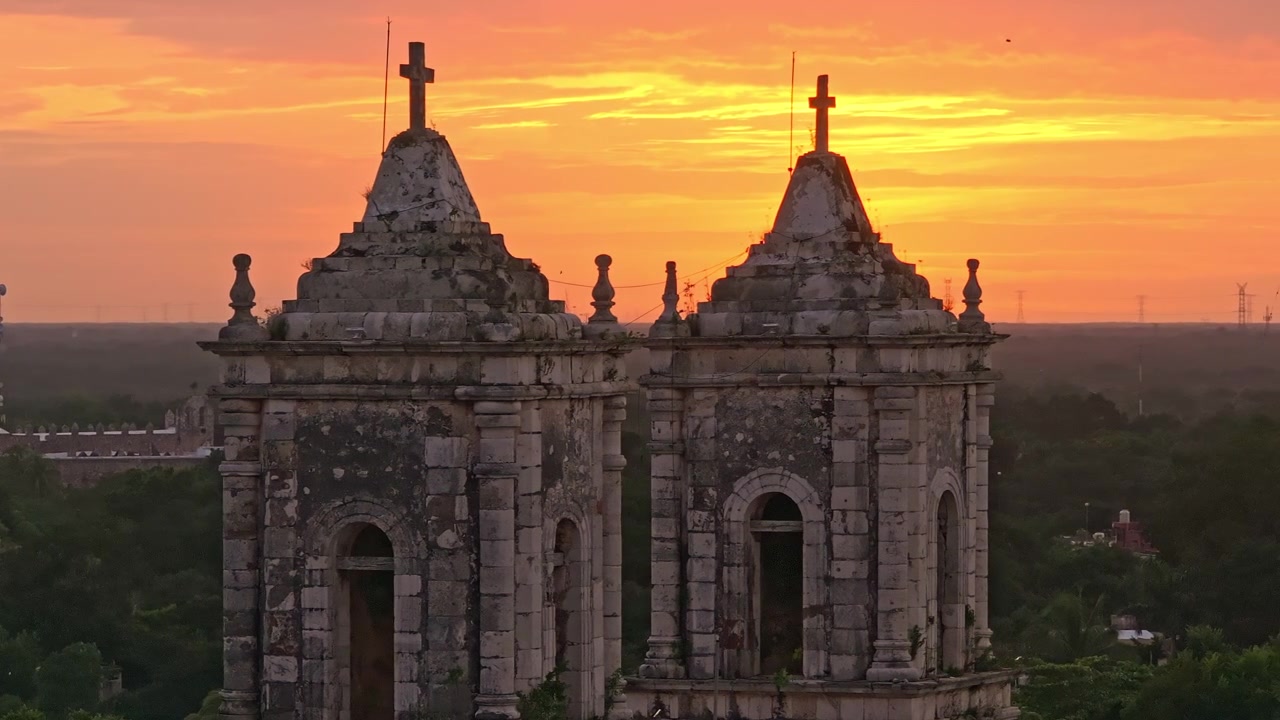 Vista aerea con drone della Cattedrale di San Gervasio e dei suoi campanili gemelli a Valladolid, Yucatan, Messico, che risplende sotto un caldo cielo dell'ora d'oro