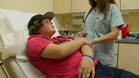 a nurse gives a worried patient a shot