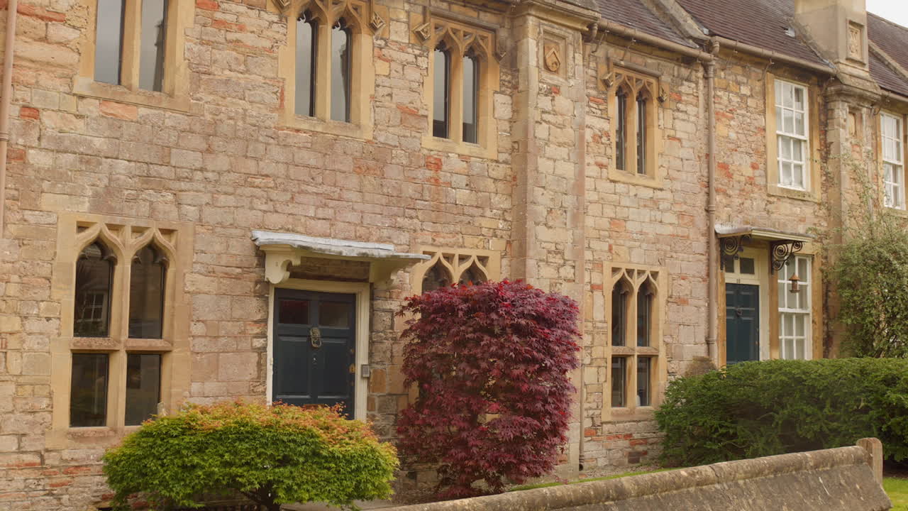 Historic homes with stone facades and lush greenery in Vicar's Close, Wells, England