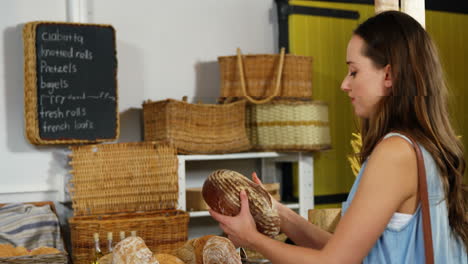 woman smelling bread at bakery section