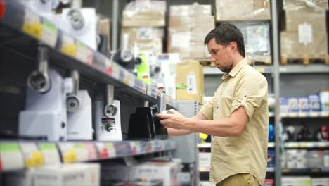 man shopping for meat grinder in a grocery store