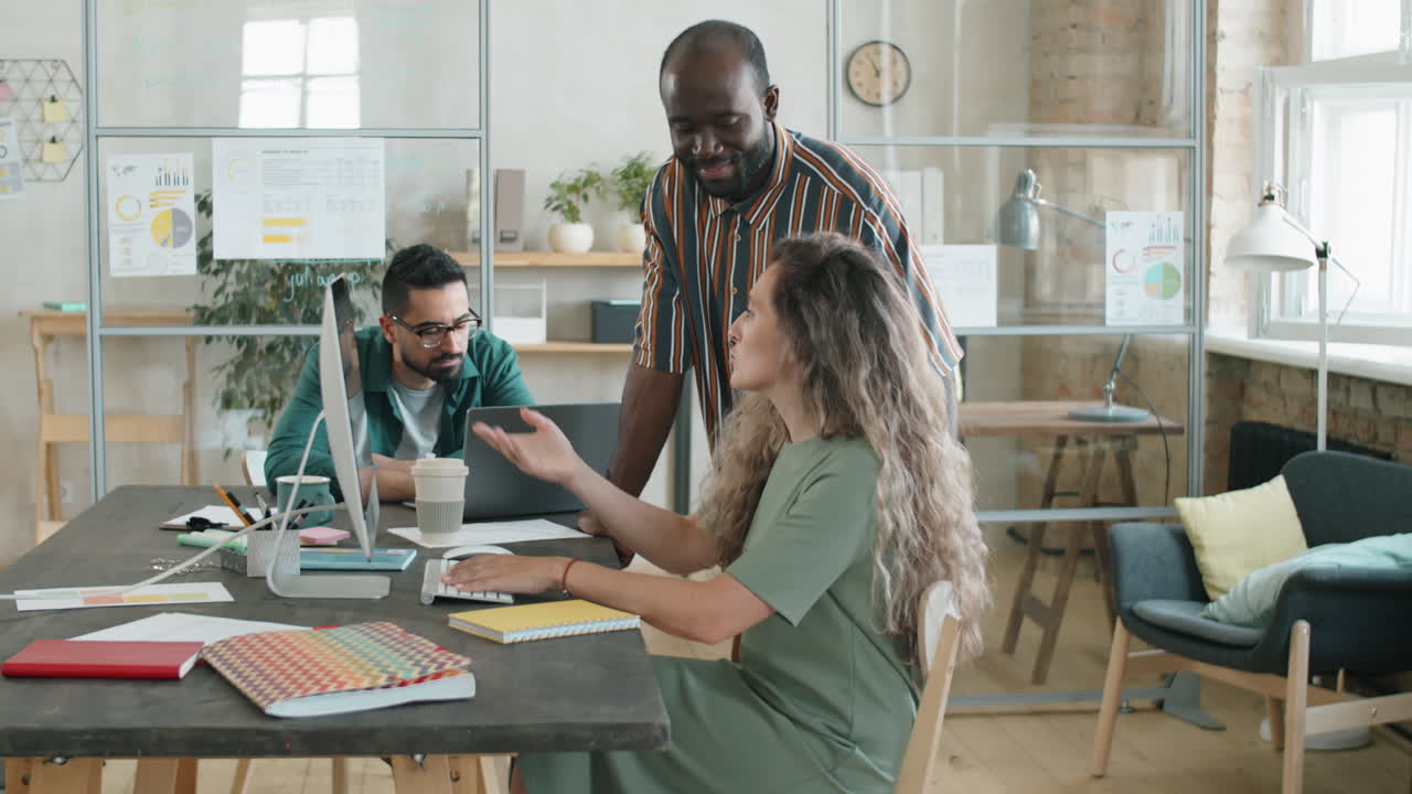 African American Man and Caucasian Woman Discussing Project on Computer in Office