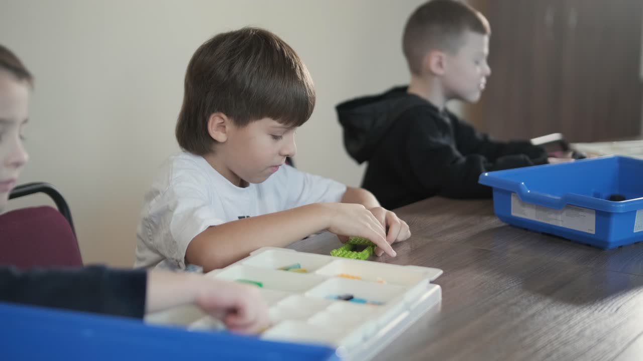 Children engage in STEM learning activities, assembling robotics kits with focus and teamwork in a classroom setting