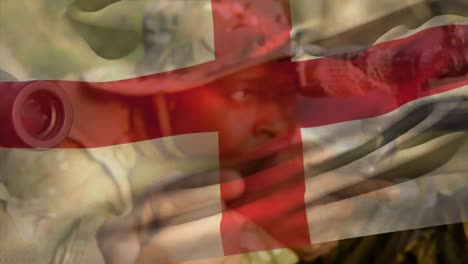 Animation-of-flag-of-england-over-african-american-male-soldier-with-weapon