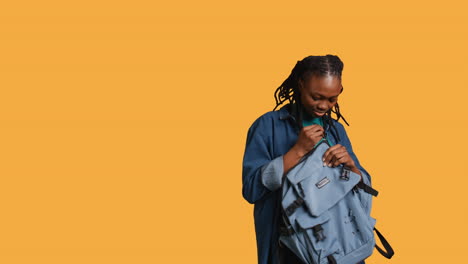mujer sacando la computadora portátil de la mochila, preparándose para comenzar el trabajo, fondo de estudio