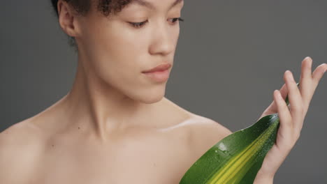 close up portrait attractive young woman touching leaf caressing smooth healthy skin complexion enjoying playful natural beauty on grey background skincare concept