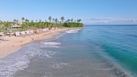 Aerial-forward-at-low-altitude-along-private-beach-of-Nickelodeon-Resort,-Punta-Cana-in-Dominican-Republic