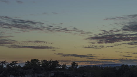 sunset time lapse of clouds forming above forest, summer evening in south norway