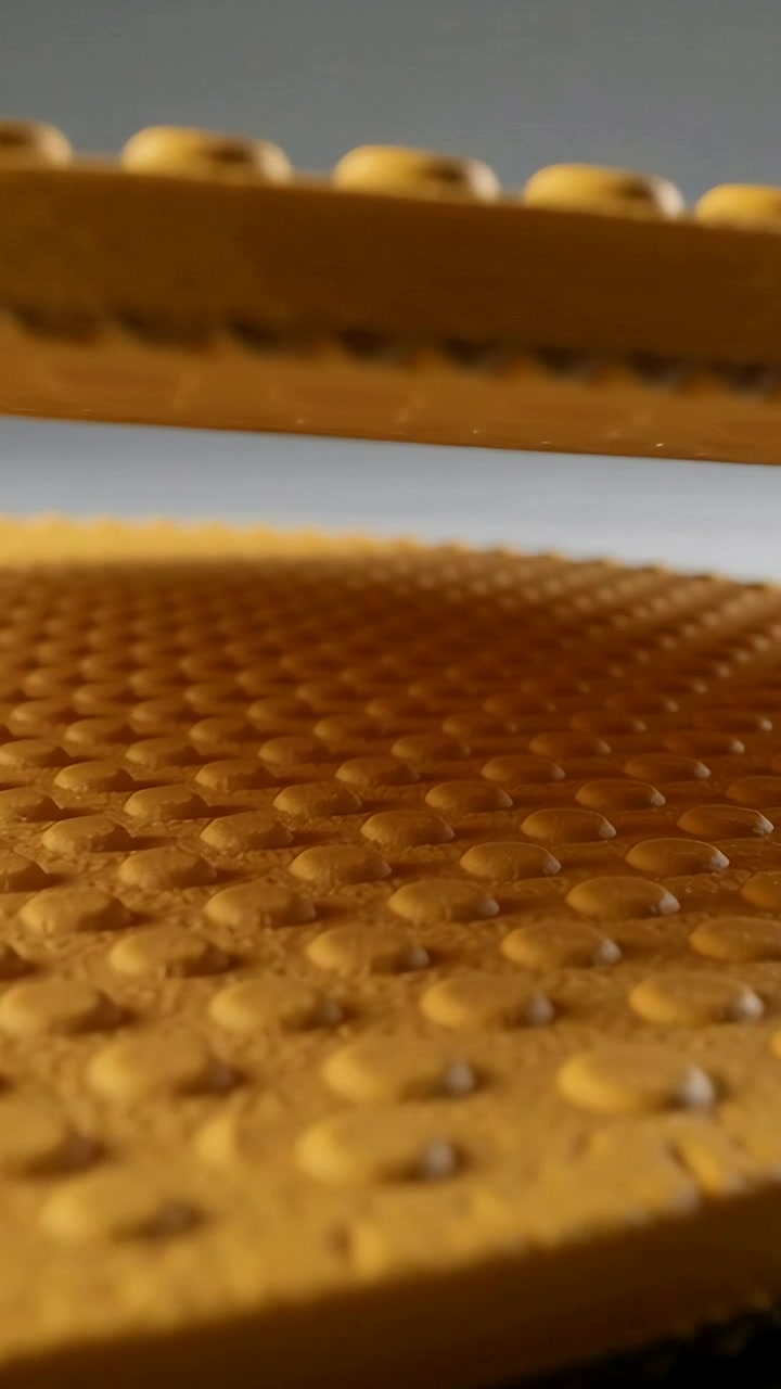 Vertical video: Shifting camera making parallax on two yellow bumpy plates on shelf revealing bumps