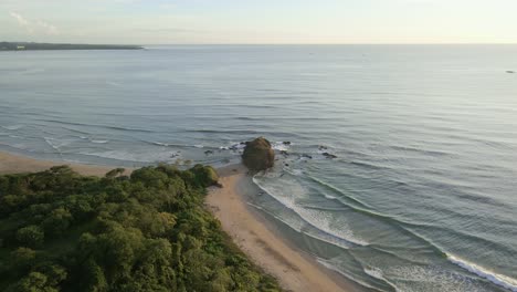 Drone-Acercándose-A-Una-Gran-Roca-En-La-Punta-De-Una-Península-En-Una-Playa-Paradisíaca-En-Costa-Rica