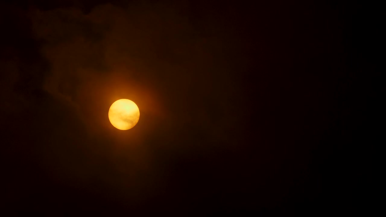 The sun peaking through clouds on a cloudy day