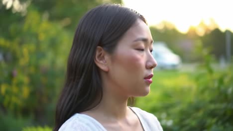 a serene moment: capturing the contemplative expression of a young woman in a lush outdoor setting, embraced by nature's beauty and tranquility